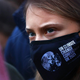 A closeup shot of Swedish climate activist Greta Thunberg as she takes part in a protest at Festival Park in Glasgow wearing a COP26 mask.